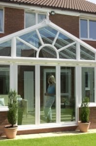 Lady looking out of the window in a victorian conservatory